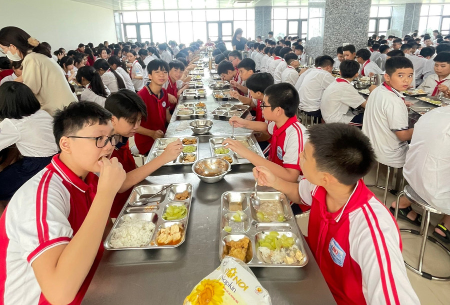 Học sinh Trường THCS Mai Dịch (Hà Nội) ăn bán trú tại bếp ăn nhà trường. 