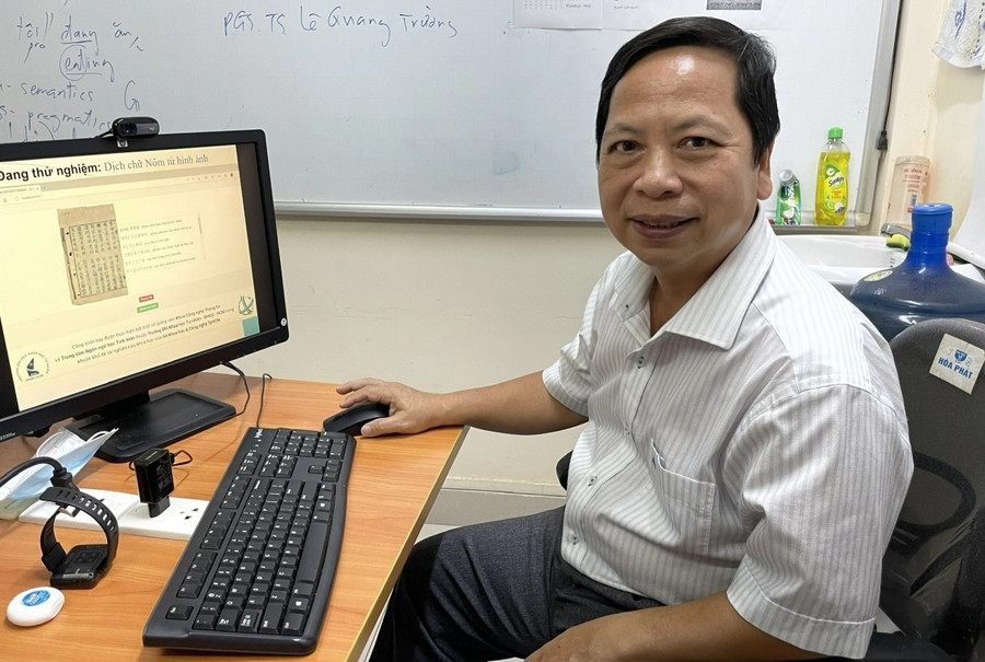 PGS.TS Đinh Điền bên sản phẩm ứng dụng AI chuyển chữ Nôm sang chữ Quốc ngữ do ông và các cộng sự nghiên cứu. Ảnh: Hà An