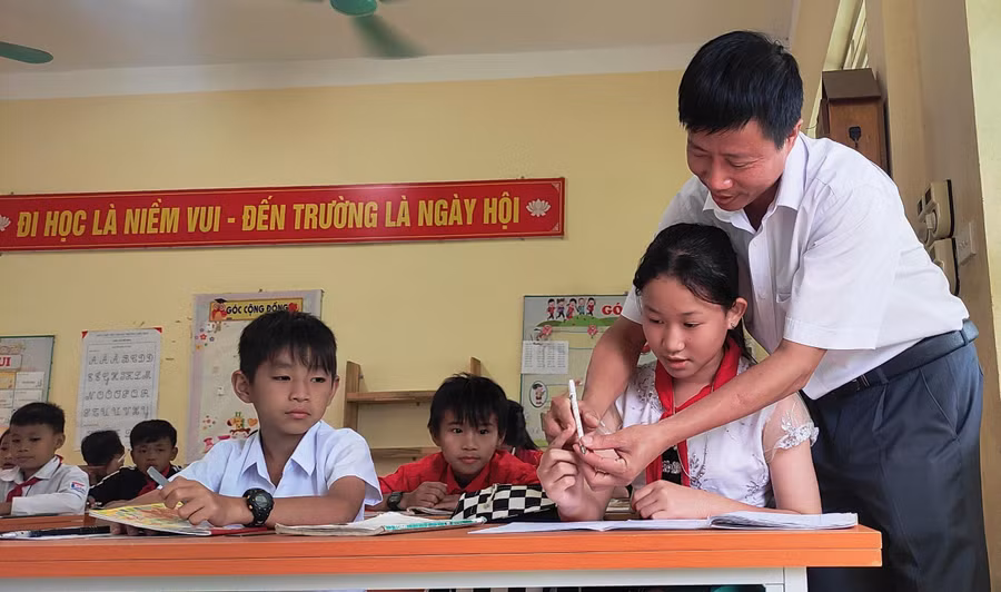 Thầy Lê Xuân Viên - Hiệu trưởng Trường Tiểu học Tam Chung (Mường Lát, Thanh Hóa) cầm tay học trò chỉ từng nét viết.