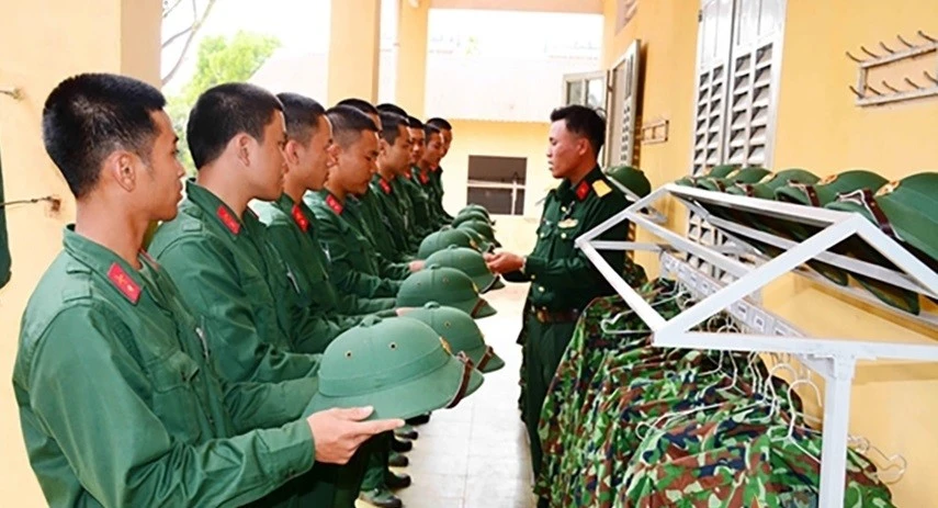 Cán bộ Trung đội 11 (Đại đội 4, Tiểu đoàn 1, Trung đoàn 48, Sư đoàn 3-Sao Vàng, Quân khu 1) hướng dẫn chiến sĩ mới cách đặt mũ. Ảnh: Lê Quang Hội 