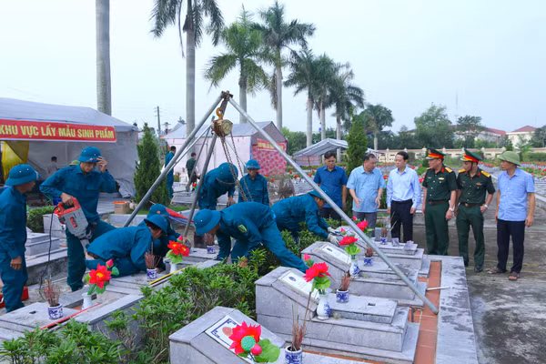 Lực lượng chức năng lấy mẫu sinh phẩm hài cốt liệt sĩ tại Nghĩa trang Liệt sĩ Đông Hưng. Ảnh: Đinh Chiến