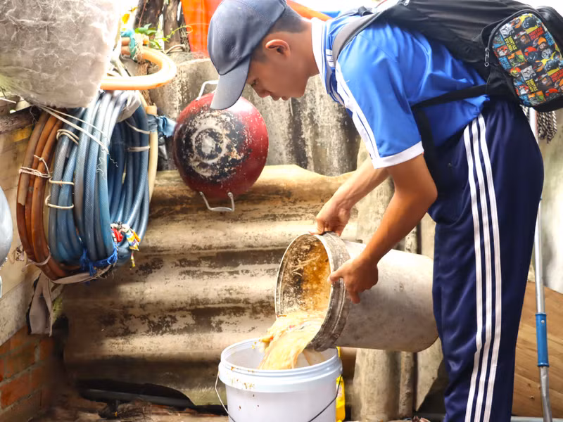 Sau khi bán xong phế liệu, Hữu Do sẽ đi xin đổ thức ăn thừa của một số nhà dân trong khu vực thị trấn Năm Căn để về nhà cho heo ăn. do-13.jpg