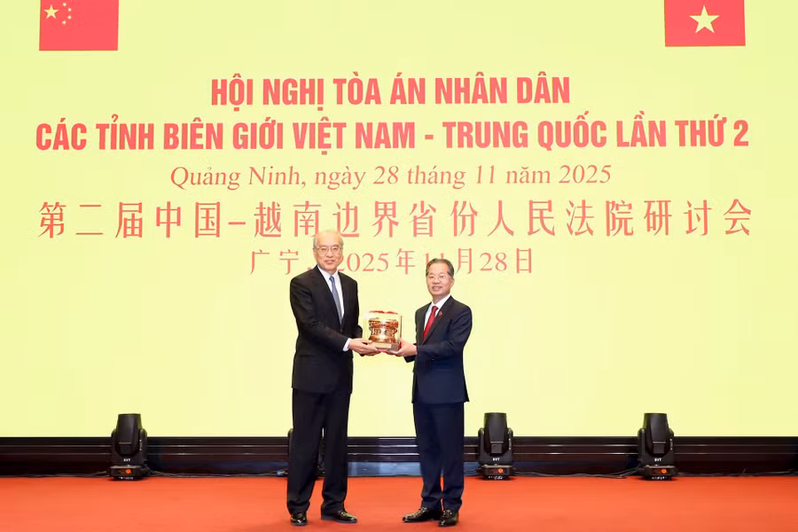 Chánh án Nguyễn Văn Quảng trao quà kỷ niệm tặng Chánh án Trương Quân.