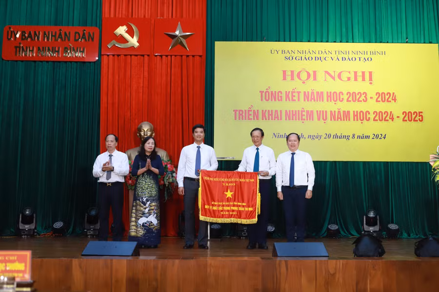 Thứ trưởng Bộ GD&ĐT Phạm Ngọc Thưởng (thứ 2 từ phải sang) trao Cờ thi đua của Chính phủ cho đại diện Sở GD&ĐT Ninh Bình. 