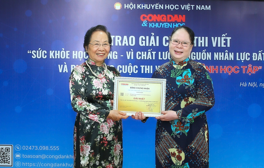 Nguyên Phó Chủ tịch nước Nguyễn Thị Doan (trái) trao giải Nhất cuộc thi viết "Sức khỏe học đường - vì chất lượng nguồn nhân lực đất nước" cho tác giả Trương Thị Mai.