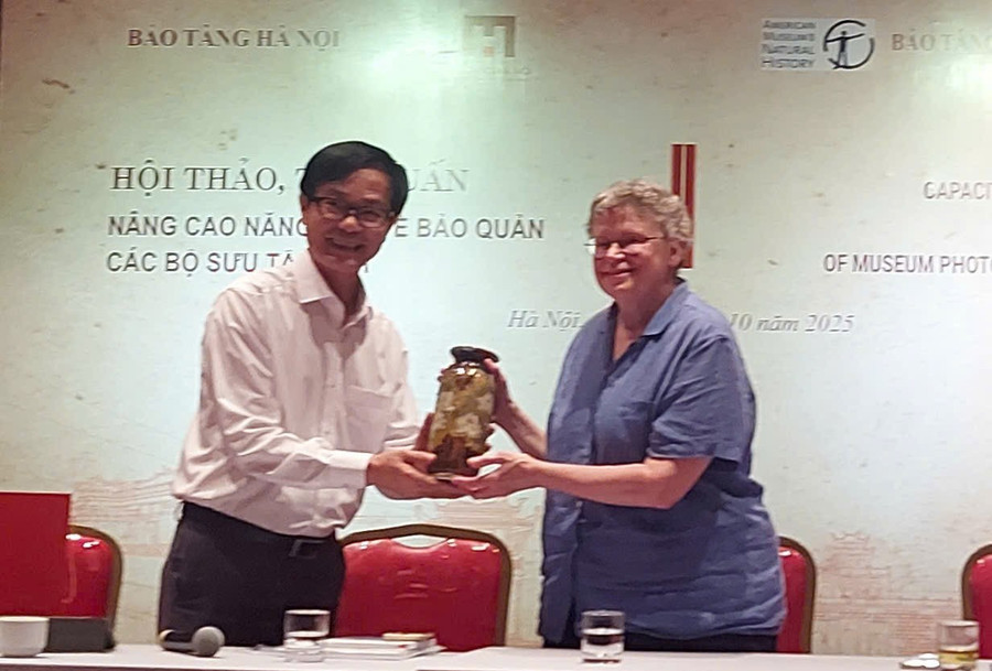 Ông Nguyễn Tiến Đà, Giám đốc Bảo tàng Hà Nội tặng quà kỷ niệm cho bà Barbara (phải) trong buổi khai mạc sự kiện. Ảnh: Bình Thanh