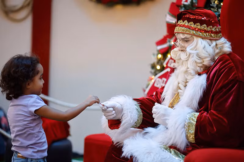 Ông già Noel tặng kẹo mút cho một em bé trong trung tâm mua sắm ở Brasilia, Brazil. Chùm ảnh thế giới hân hoan đón ông già Noel