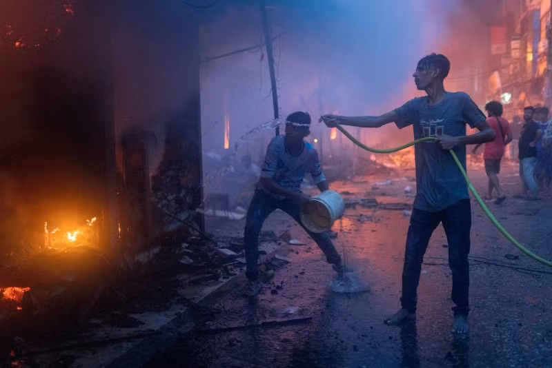 Mọi người nỗ lực dập tắt một phần đám cháy bùng phát tại chợ Mohammadpur Krishi ở Dhaka. Cháy chợ ở Bangladesh, hàng trăm cửa hàng bị thiêu rụi