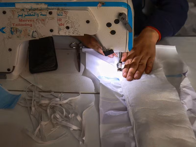 Người mẹ 3 con Inas Al Masry, đã sử dụng thứ trông giống như một chiếc quần đùi nhỏ xíu được làm từ nhựa màu hồng trong suốt để bảo vệ một trong những đứa con của mình. Chùm ảnh thợ may Gaza thời chiến