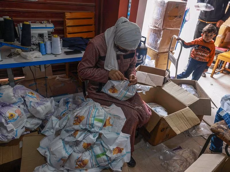 Abu Gharara cho biết họ dùng quần áo bảo hộ tái chế có từ đại dịch COVID-19 làm nguyên liệu tã lót, hy vọng chúng giúp ích cho các gia đình đang chịu đựng điều kiện khắc nghiệt. Chùm ảnh thợ may Gaza thời chiến