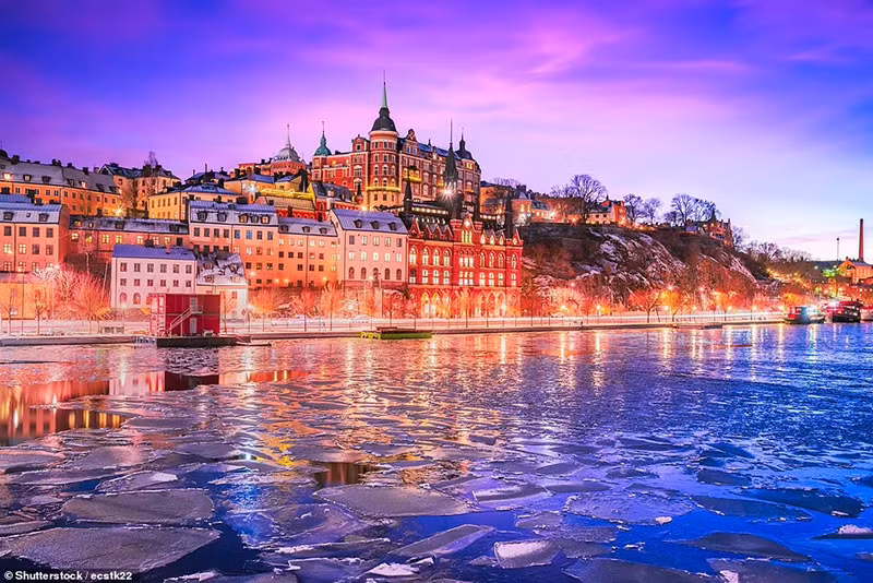 Đảo Södermalm dưới bầu trời màu tím hồng tuyệt đẹp, được phản chiếu trên Hồ Malaren đóng băng một phần ở Stockholm, Thụy Điển. Ngắm những thành phố đẹp như cổ tích trong mùa đông