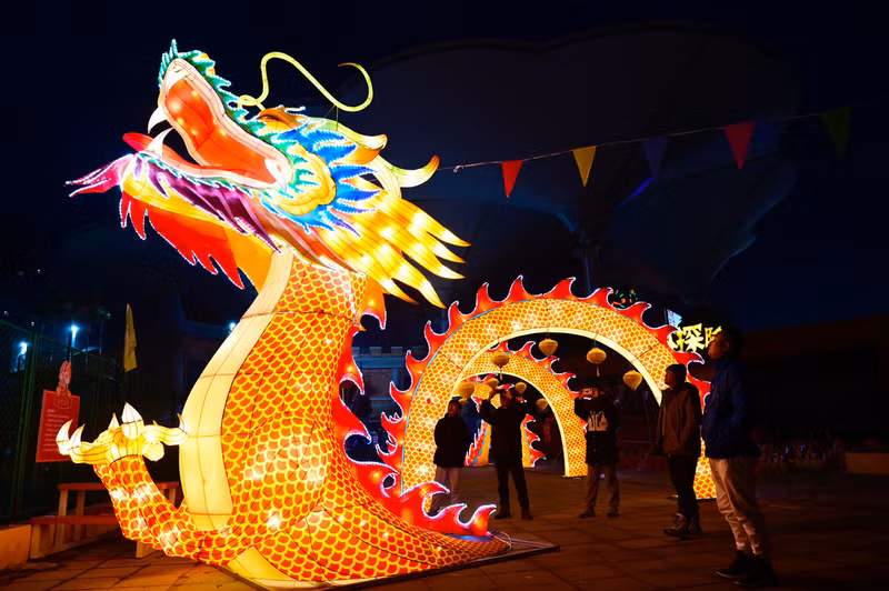 Khách du lịch chụp ảnh đèn lồng rồng được trưng bày ở quận Dongchangfu của LiaoThành, tỉnh Sơn Đông, miền Đông Trung Quốc. (Ảnh: Tân Hoa Xã) Đèn lồng đón năm con rồng rực rỡ khắp Trung Quốc