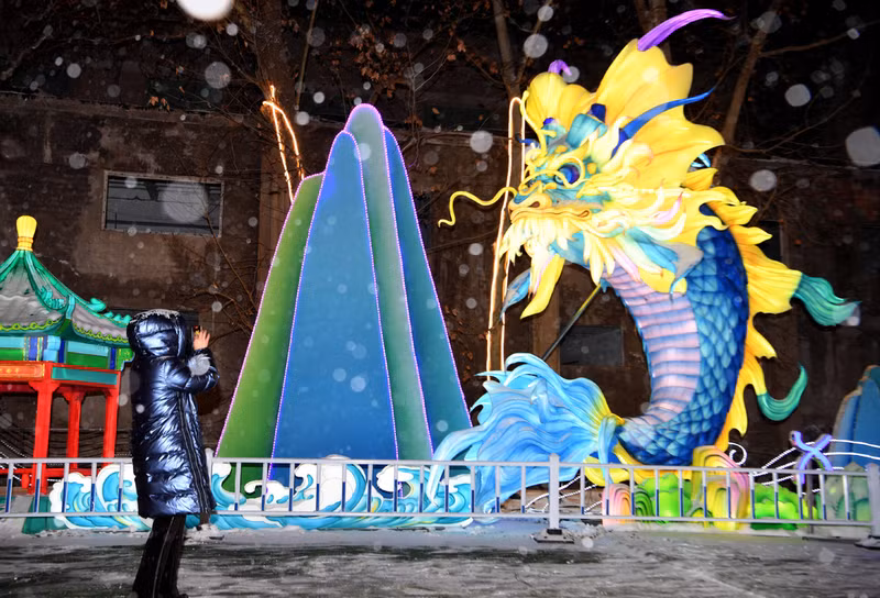 Một khách du lịch chụp ảnh chiếc đèn lồng rồng được trưng bày tại Khu công nghiệp Văn hóa và Sáng tạo Ersha ở Zhengzhou, tỉnh Hà Nam, miền Trung Trung Quốc. (Ảnh: Tân Hoa Xã) Đèn lồng đón năm con rồng rực rỡ khắp Trung Quốc