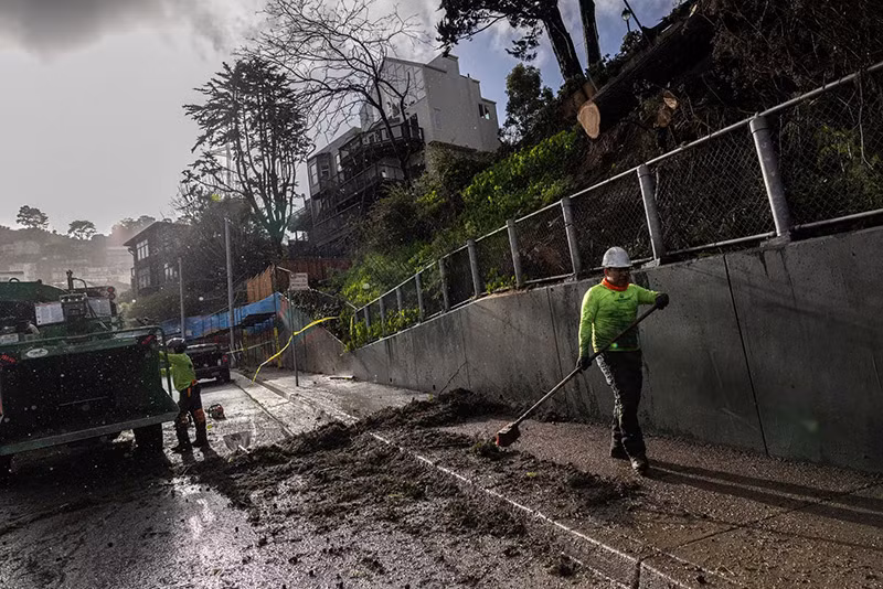 Công nhân dọn dẹp khu vực có cây đổ khi cơn bão Thái Bình Dương được gọi là "sông khí quyển" tiến đến miền bắc California, mang theo mưa lớn và gió có thể gây ra lũ lụt. Chùm ảnh bão ‘sông khí quyển’ tàn phá California