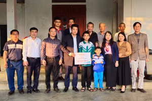 Đại diện Báo GD&TĐ cùng chính quyền địa phương trao quà bạn đọc đến với gia đình em Lê Trung Tuấn Phong.