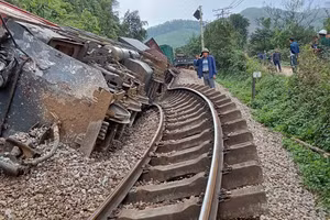 Đầu máy và 3 toa tàu hàng bị lật nghiêng. (Ảnh: Thành Tâm)