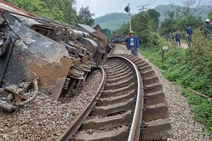 Đầu máy và 3 toa tàu hàng bị lật nghiêng. (Ảnh: Thành Tâm)