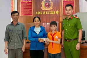 Bố con em Duy đến trụ sở công an trả lại tiền cho người đánh rơi. (Ảnh: Công an cung cấp)