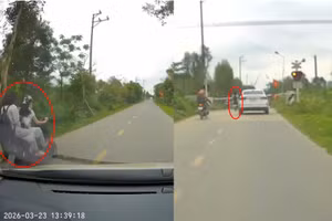 Hai nữ sinh điều khiển xe điện vượt rào chắn khi tàu đến gần. (Ảnh cắt từ clip)