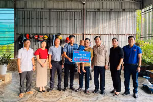 Đại diện VP Báo GD&TĐ cùng chính quyền địa phương trao số tiền bạn đọc ủng hộ 2 anh em sinh đôi bị ung thư.