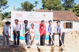 Các đại biểu và nhà tài trợ thực hiện nghi thức khởi công nhà nhân ái cho bà Hoa. 