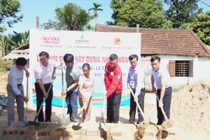 Các đại biểu và nhà tài trợ thực hiện nghi thức khởi công nhà nhân ái cho bà Hoa. 