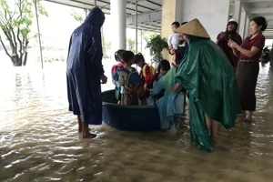 Lực lượng chức năng và giáo viên hỗ trợ đưa học sinh ra khỏi khu vực ngập ở Trường Mầm non Kỳ Thịnh (Phường Vũng Áng, Hà Tĩnh).