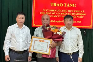 Ông Võ Văn Phấn nhận Giấy khen của Chủ tịch UBND xã Cẩm Bình vì hành động dũng cảm cứu người. (Ảnh:D.Q)