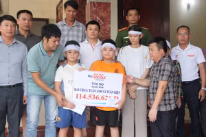 Đại diện Báo GD&TĐ cùng chính quyền địa phương trao quà bạn đọc đến 2 cháu nhỏ.