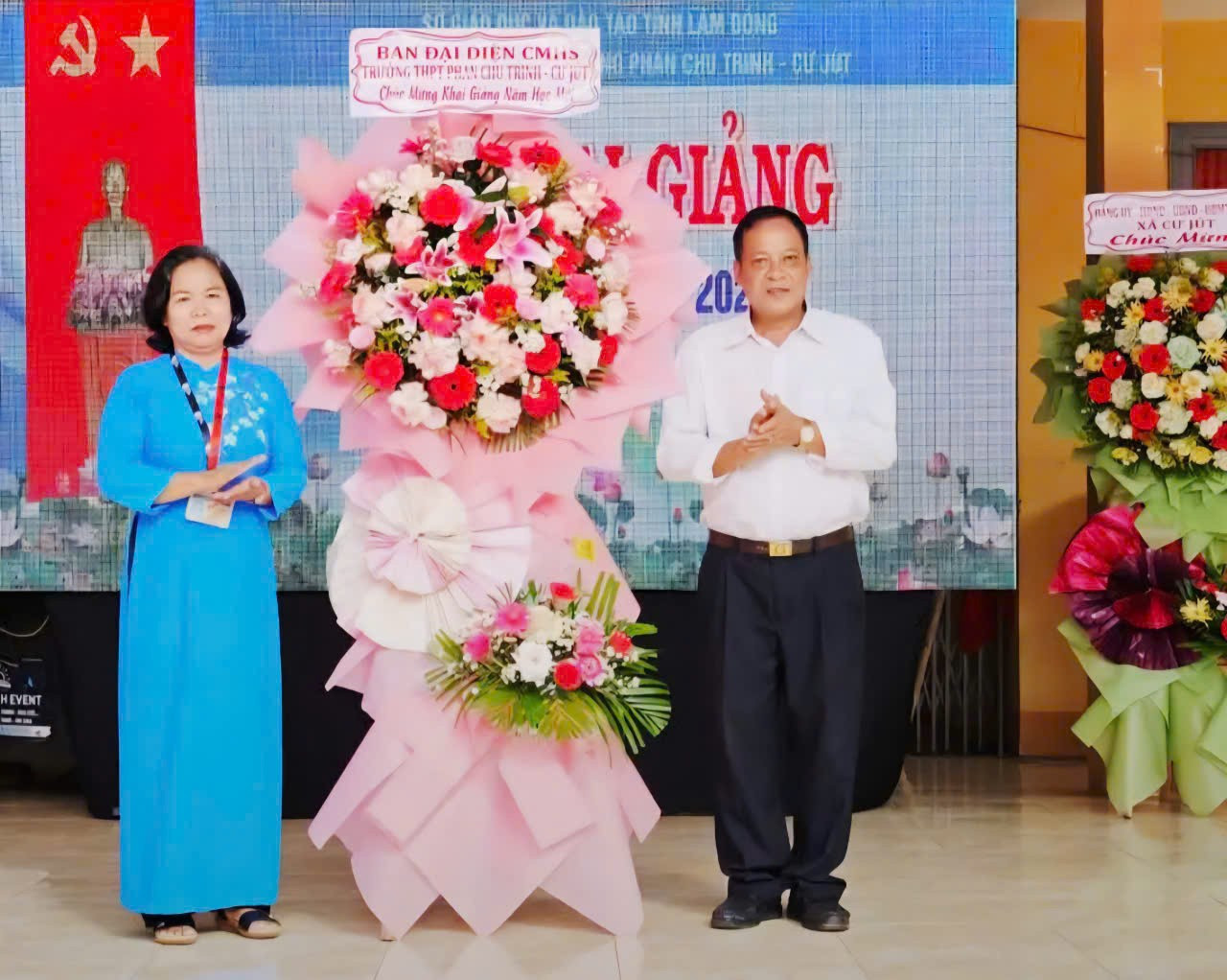 Hiệu trưởng Trần Thị Hiền đón nhận lẵng hoa từ Ban đại diện cha mẹ học sinh trong lễ khai giảng năm học 2025-2026. pct1.jpg
