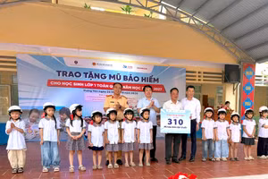 Đại diện các đơn vị trao tặng mũ bảo hiểm cho học sinh, phụ huynh, giáo viên.