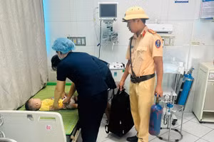 Trung tá Ngô Văn Quỳnh hỗ trợ đưa cháu bé bị co giật vào bệnh viện cấp cứu.