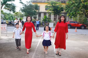 Cô giáo ân cần dắt tay học sinh lớp 1 trong ngày đầu tiên tới trường.