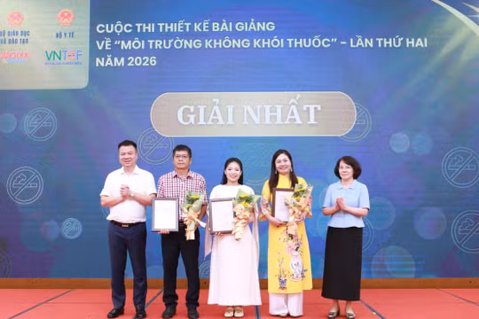 Nhà báo Triệu Ngọc Lâm và bà Phan Thị Hải trao giấy chứng nhận và hoa cho các tác giả đạt giải Nhất.
