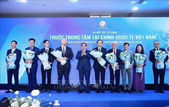 Thủ tướng Phạm Minh Chính tặng hoa cho đại diện các cơ quan thuộc Trung tâm Tài chính quốc tế Việt Nam. Ảnh: Dương Giang/TTXVN