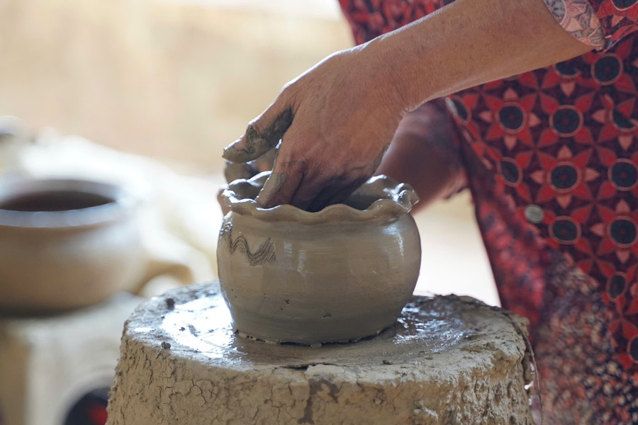 Những người thợ thủ công chăm chú hoàn thiện từng sản phẩm. Tiếng bàn tay chạm đất sét hòa cùng không gian tạo nên một bức tranh lao động dung dị mà đầy chất thơ. 29.png
