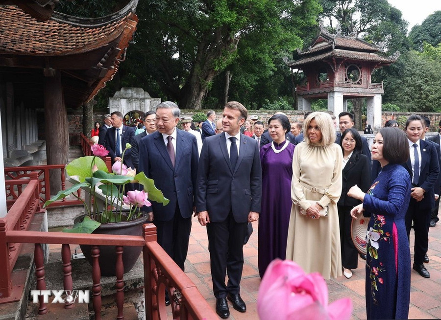 Tổng Bí thư Tô Lâm và Phu nhân cùng Tổng thống Pháp Emmanuel Macron và Phu nhân nghe giới thiệu về 82 bia Tiến sỹ- Di sản tư liệu thế giới. (Ảnh: Thống Nhất/TTXVN). 271-1648.jpg