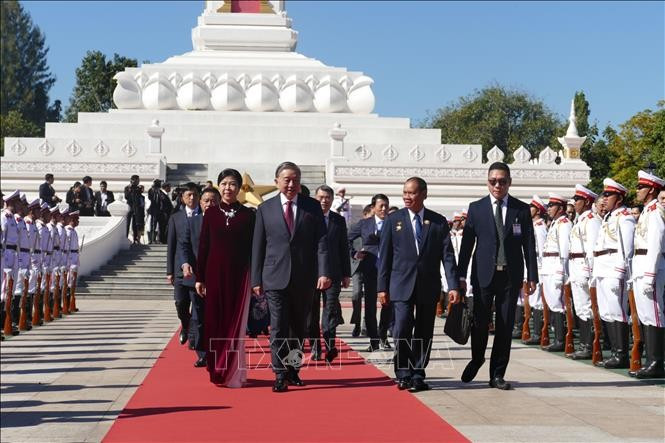 Tổng Bí thư Tô Lâm và Phu nhân Ngô Phương Ly cùng Đoàn đại biểu cấp cao Việt Nam đến đặt vòng hoa tại Đài tưởng niệm các chiến sĩ vô danh. Ảnh: Xuân Tú/ PV TTXVN tại Lào