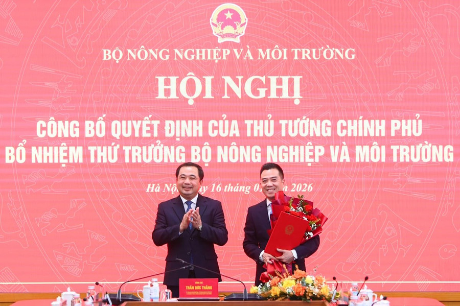 Bộ trưởng Trần Đức Thắng tặng hoa chúc mừng tân Thứ trưởng Bộ Nông nghiệp và Môi trường Đặng Ngọc Điệp. Ảnh: Tùng Đinh.