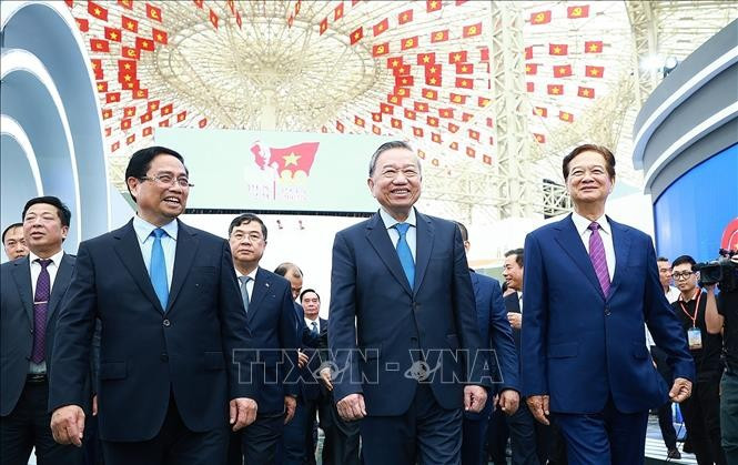 Tổng Bí thư Tô Lâm và Thủ tướng Phạm Minh Chính tham quan trưng bày thành tựu của đất nước tại Trung tâm Triển lãm Việt Nam. (Ảnh: Dương Giang/TTXVN)