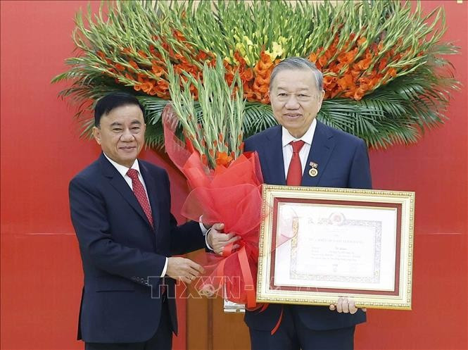 Đồng chí Trần Cẩm Tú, Uỷ viên Bộ Chính trị, Thường trực Ban Bí thư trao Huy hiệu Đảng và tặng hoa chúc mừng Tổng Bí thư Tô Lâm. Ảnh: Thống Nhất/TTXVN