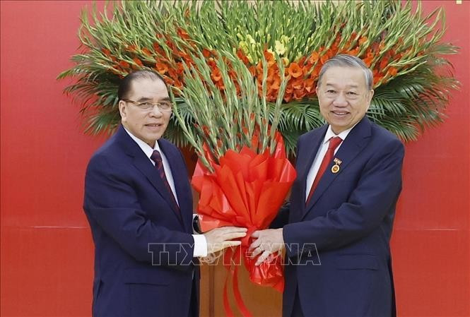 Nguyên Tổng Bí thư Nông Đức Mạnh tặng hoa chúc mừng Tổng Bí thư Tô Lâm. Ảnh: Thống Nhất/TTXVN