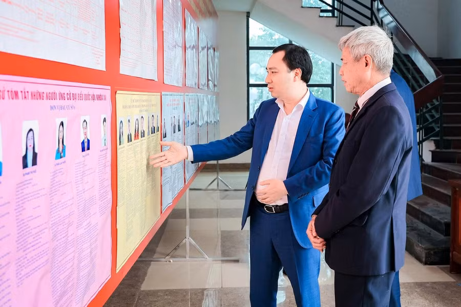 Ứng cử viên Đại biểu Quốc hội khoá XVI Vũ Văn Tiến (bên trái) trao đổi với cử tri phường Chu Văn An