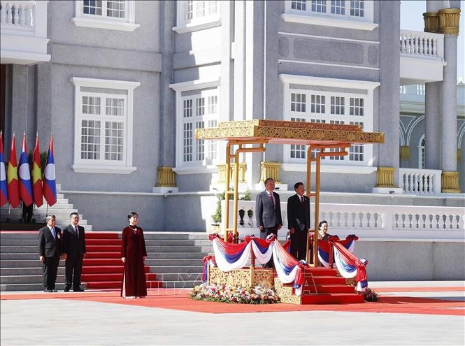 Tổng Bí thư Tô Lâm và Tổng Bí thư, Chủ tịch nước Lào Thongloun Sisoulith trên bục danh dự, nghe Quân nhạc cử Quốc thiều hai nước. Ảnh: Thống Nhất/TTXVN