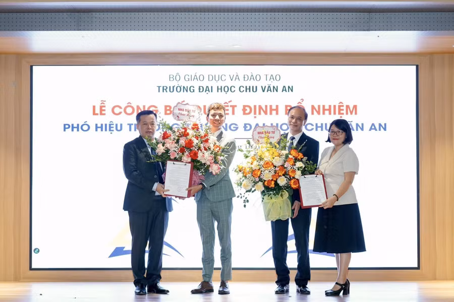 TS. Nguyễn Quốc Tư (thứ 2 từ trái sang) nhận hoa từ ông Nguyễn Thanh Việt, Chủ tịch hội đồng trường trong lễ bổ nhiệm phó hiệu trưởng Trường Đại học Chu Văn An. Ảnh: NVCC