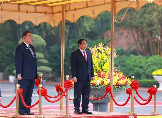 Thủ tướng Phạm Minh Chính và Thủ tướng Nhật Bản Ishiba Shigeru trên bục danh dự, nghe quân nhạc cử Quốc thiều hai nước. (Ảnh: Dương Giang/TTXVN)