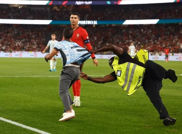 Cổ động viên quá khích xâm nhập sân bóng cố gắng tiếp cận Cristiano Ronaldo. 1.jpg