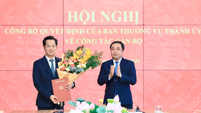 Bí thư Thành ủy Hà Nội Trần Đức Thắng trao quyết định và tặng hoa chúc mừng tân Trưởng Ban Tổ chức Thành ủy Hà Nội Vũ Đăng Định. Ảnh: QT