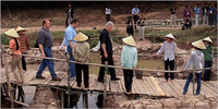 During his visit in 2000, former President Bill Clinton helped Dan and David Evert, behind him, search for the remains of their father, an airman.