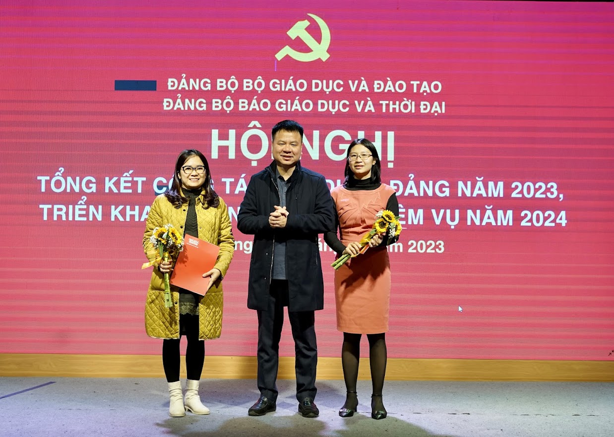 Đồng chí Bí thư Đảng uỷ Báo Giáo dục và Thời đại Triệu Ngọc Lâm trao quyết định công nhận đảng viên chính thức cho 2 đồng chí.